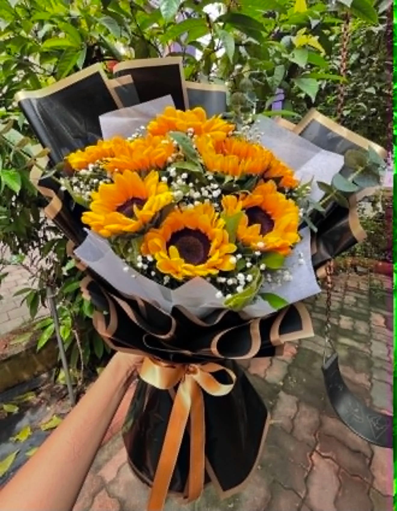Gorgeous bouquet of 10 fresh sunflowers double-wrapped elegantly in black and white, perfect for birthdays, congratulations and flower delivery in Islamabad.