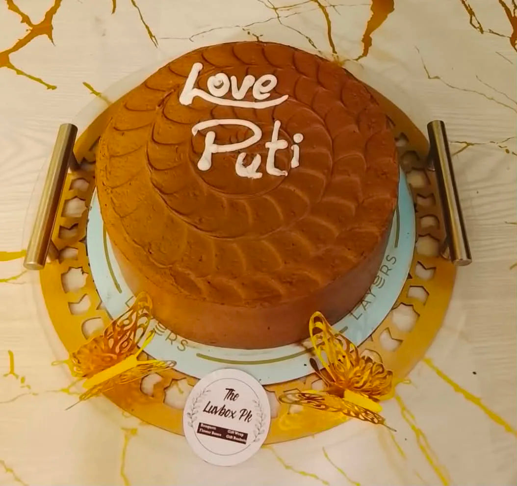 Affordable layer cake beautifully presented in a round acrylic tray with butterfly decorations, perfect for birthdays and celebrations in Islamabad.