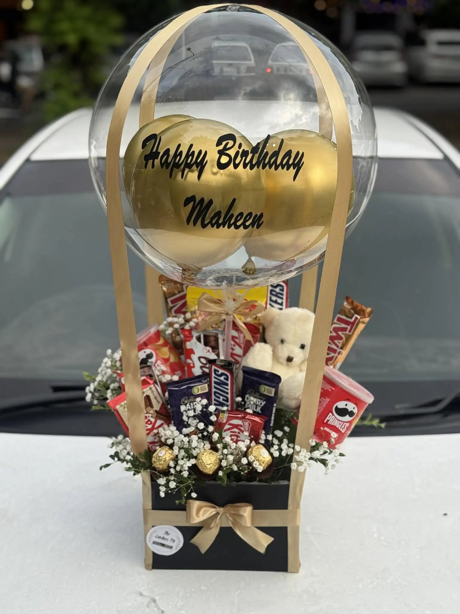 Chocolate balloon box with festive balloon and assorted chocolates for birthdays.
