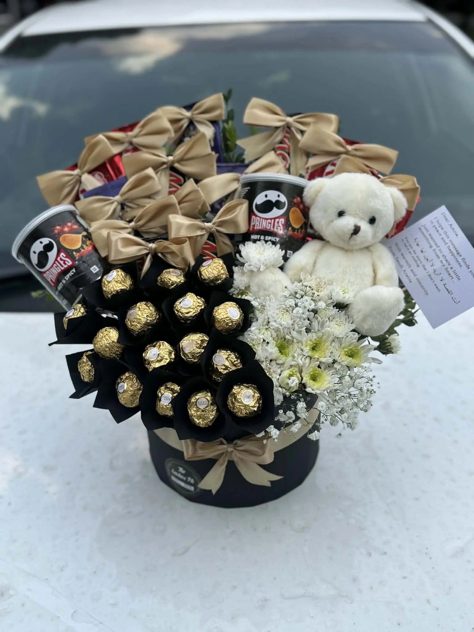 Chocolate gift box with teddy bear and fresh flowers.