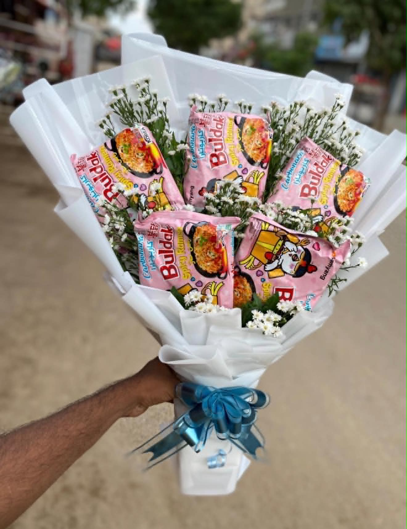 Creative Buldak noodle bouquet with 6 Korean noodles and Baby’s Breath flowers, unique gift idea for birthdays and surprises in Pakistan.