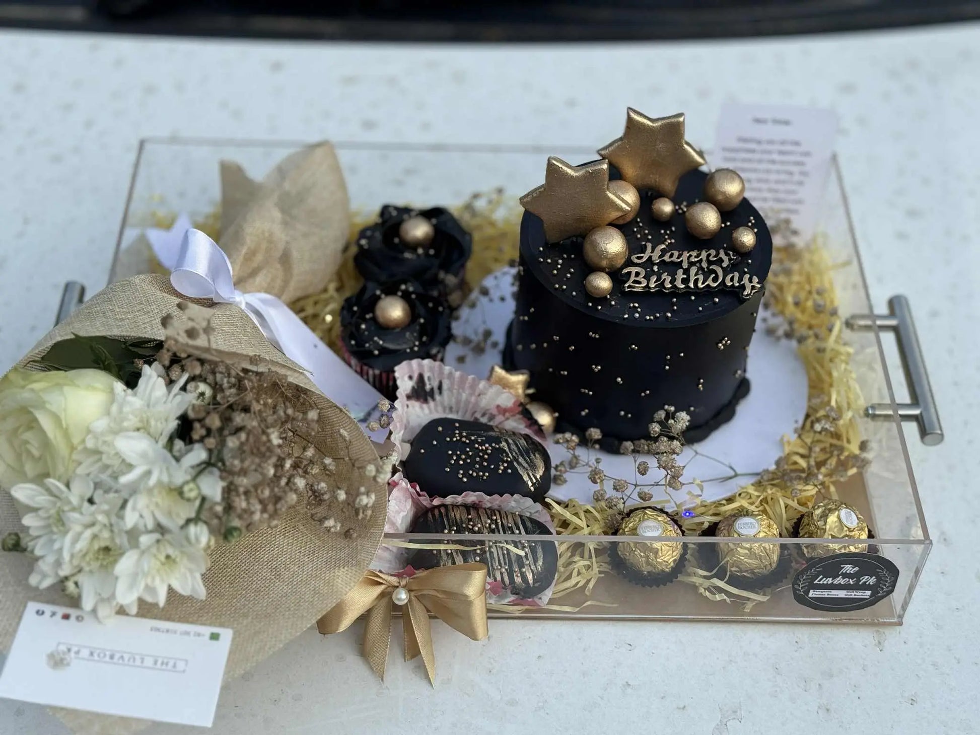 Luxury acrylic birthday tray for him with customized cake, cupcakes, flower bouquet, cakesicles, and Ferrero Rochers in Pakistan.