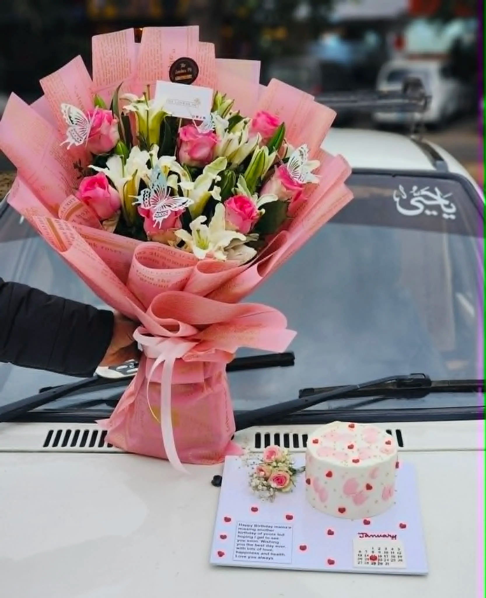 Mother’s Day combo with lily bouquet, pink roses and cake tray with calendar and message.