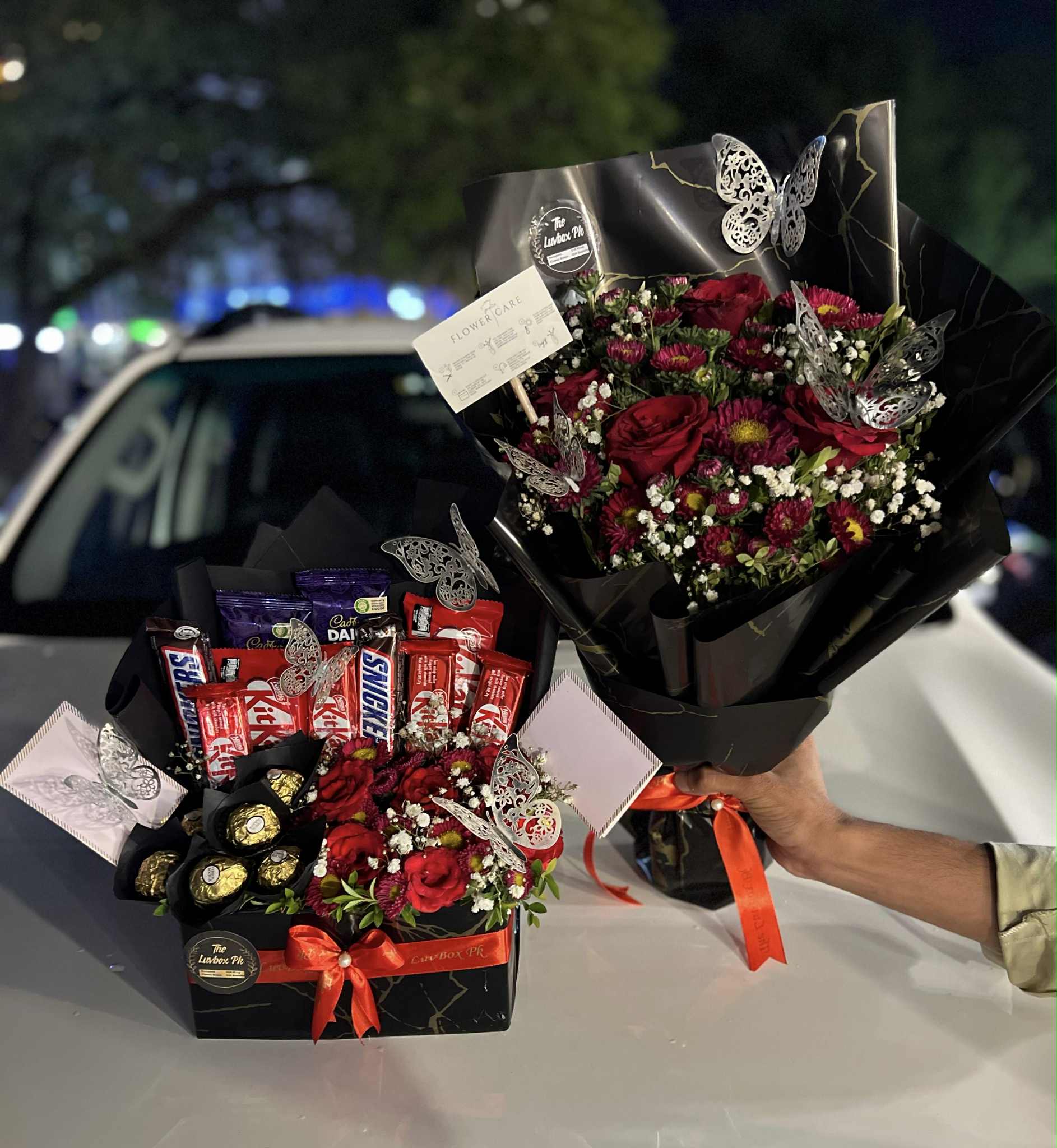 Red roses bouquet with premium chocolate box in red and black theme, perfect romantic gift for anniversaries and Valentine’s Day.