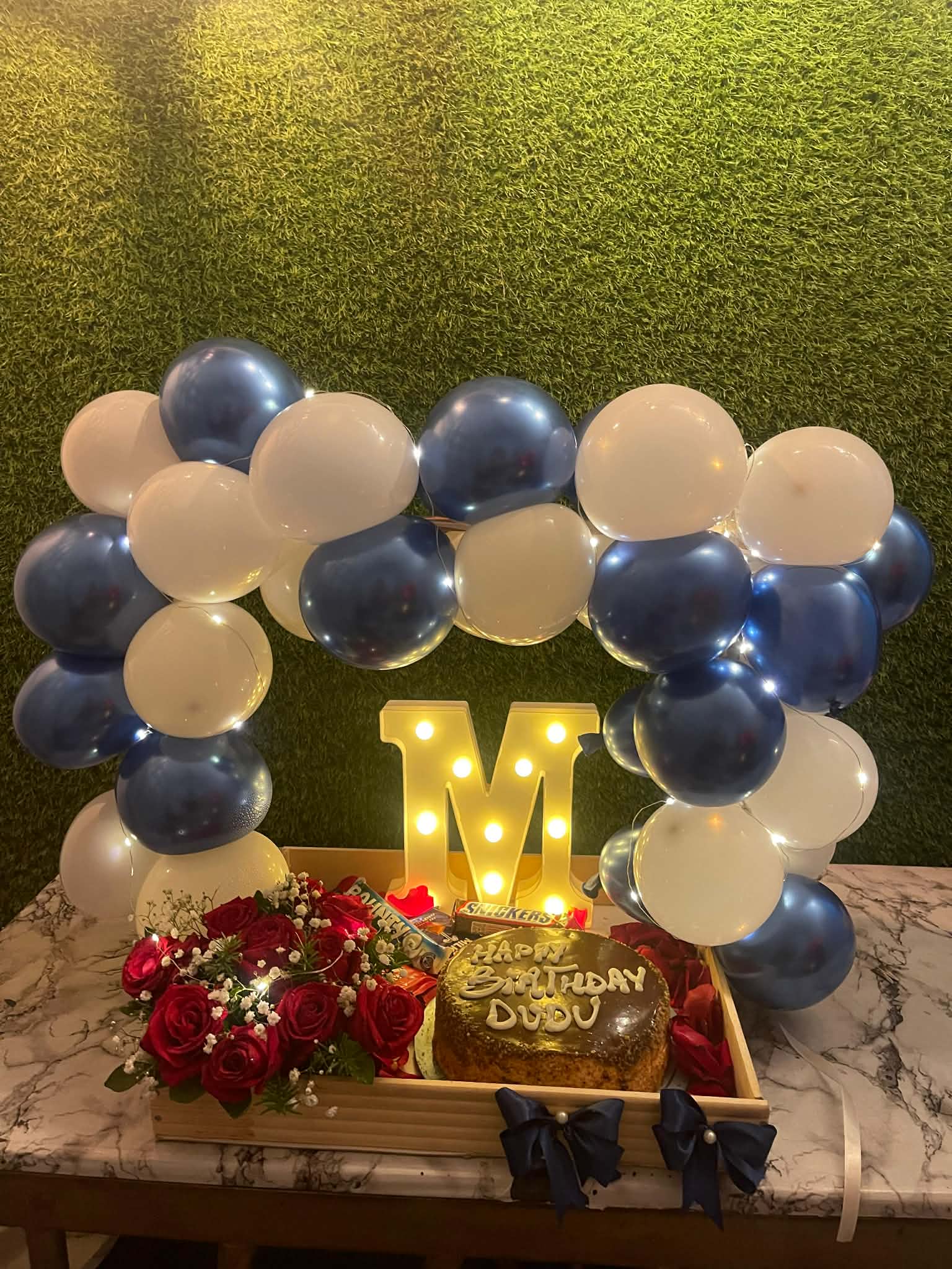 Luxury wooden tray with balloon arch, cake, flower bouquet and chocolates in Islamabad
