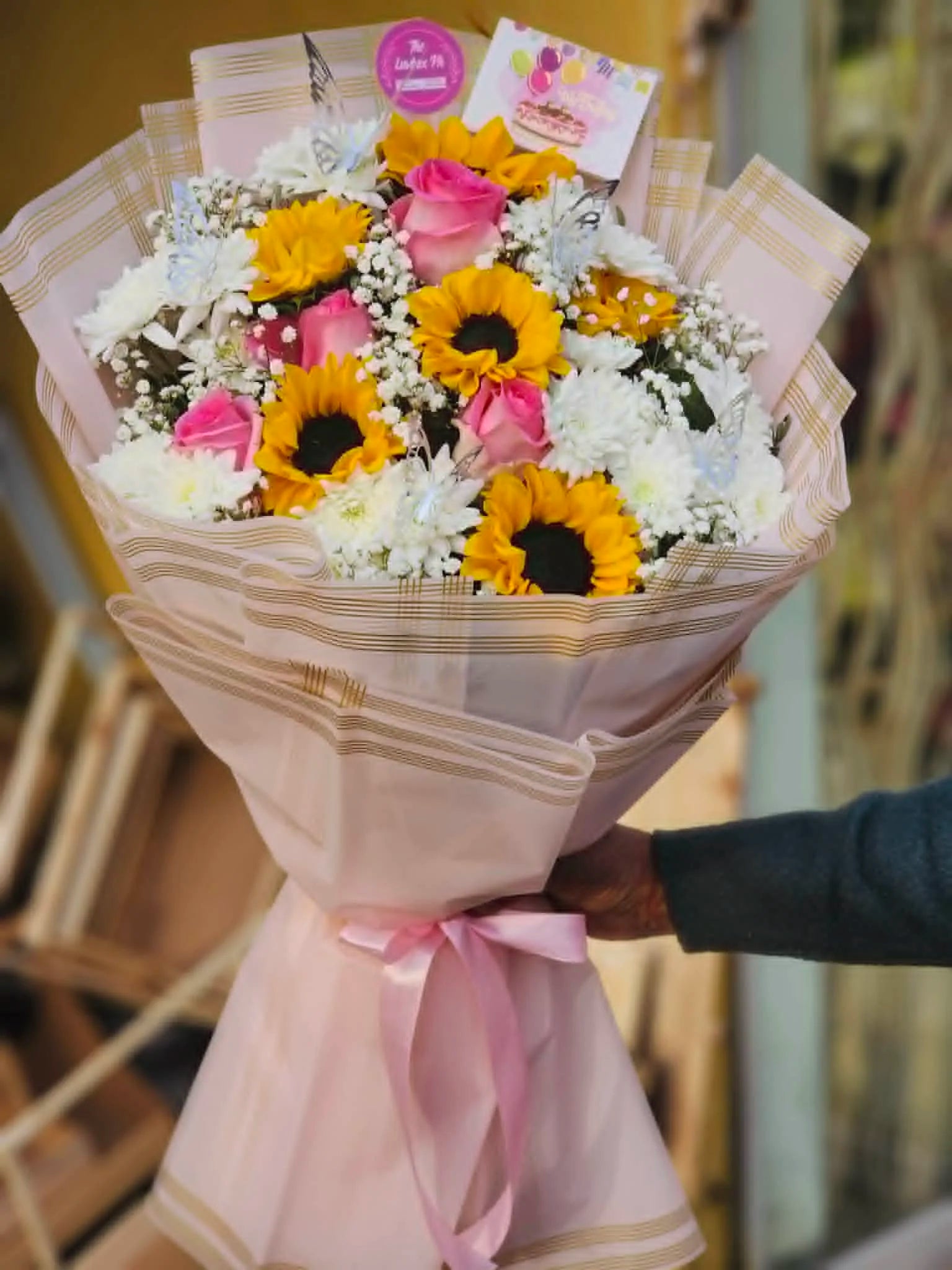 Bouquet with sunflowers, pink roses and white chrysanthemums for gifting.