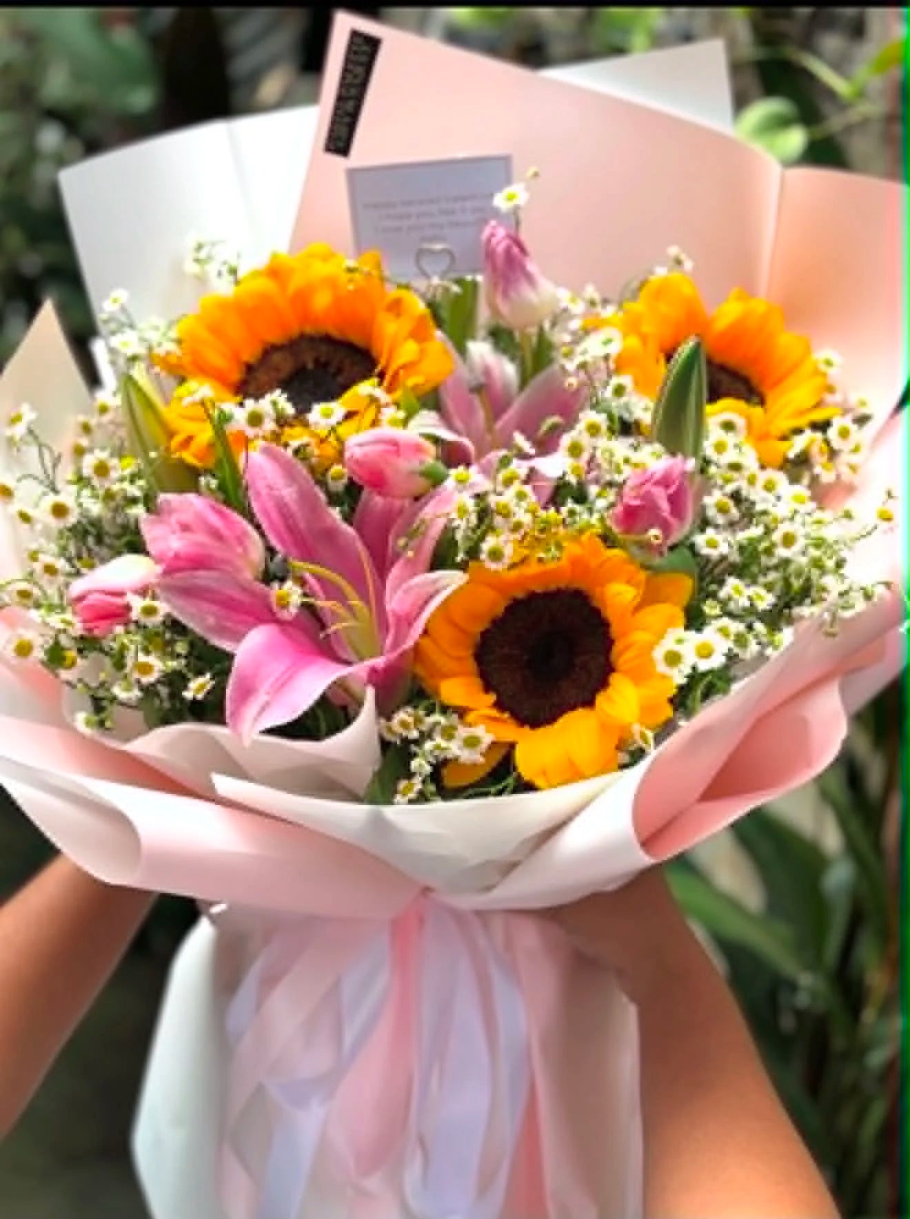 Gorgeous birthday bouquet for wife featuring pink lilies, fresh sunflowers and white Baby’s Breath, beautifully wrapped for flower delivery in Islamabad.